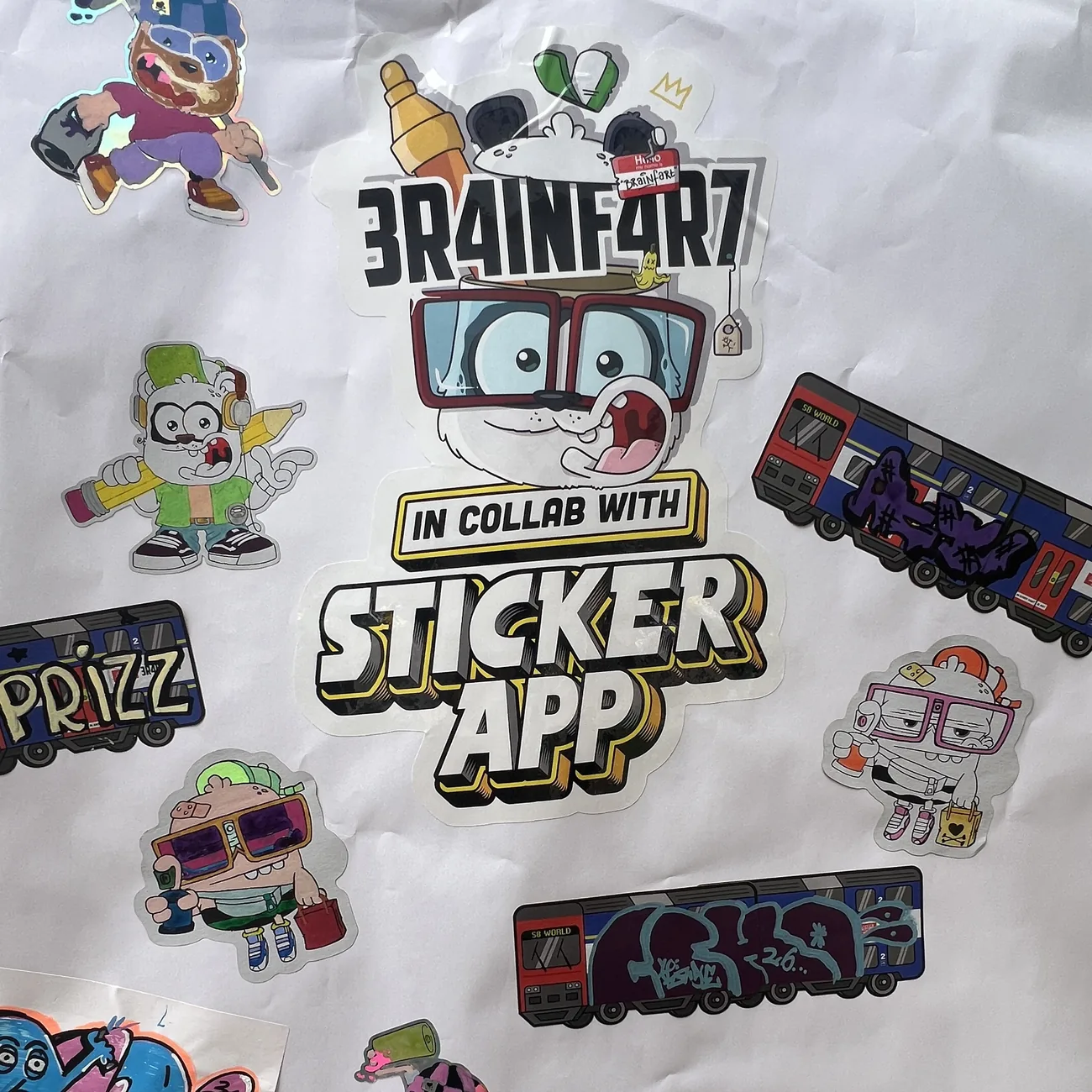 Muur vol met de hand ingekleurde contourgesneden stickers van Brainfart x StickerApp en etiketten met de S8 World-trein met graffititags