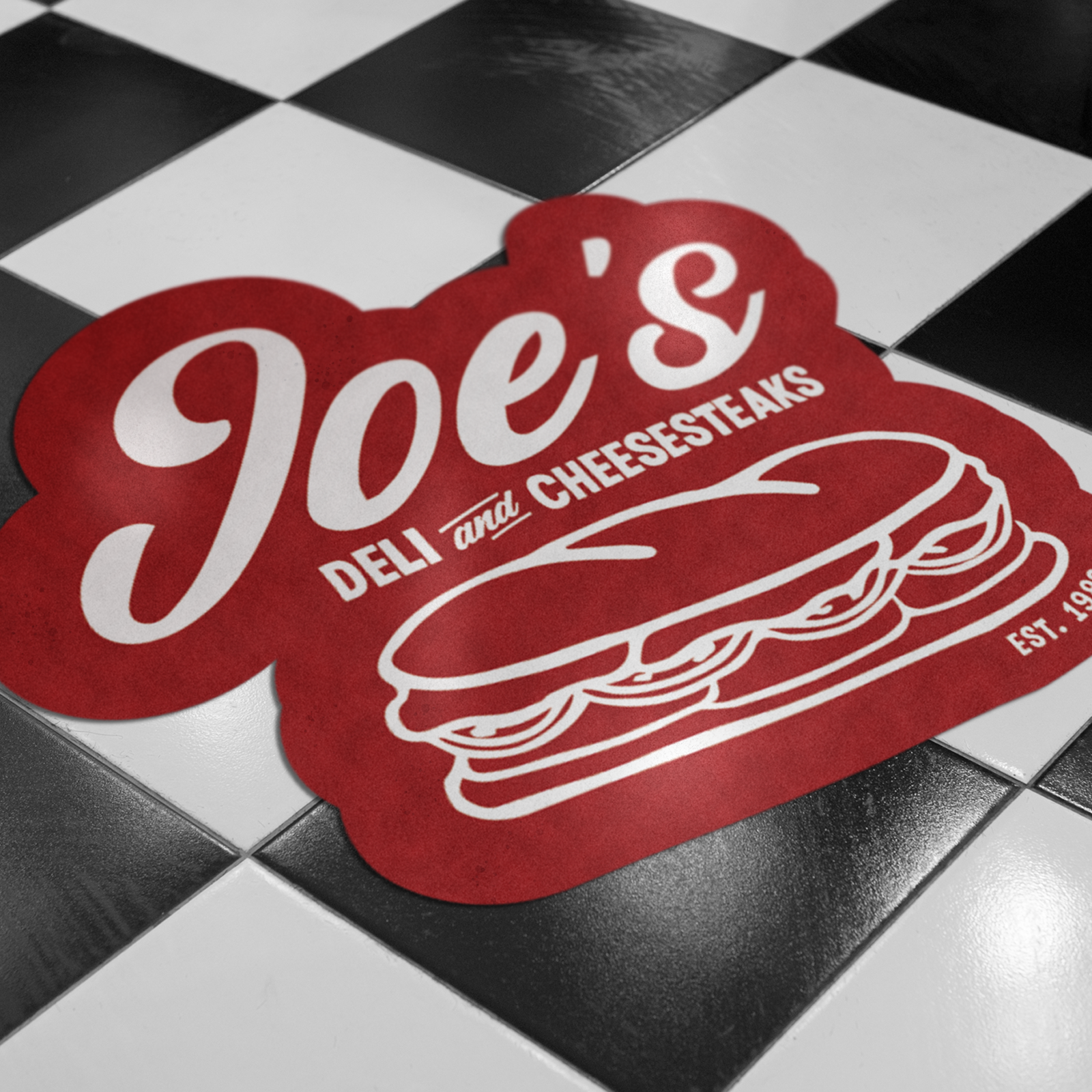 Eigen vloerdecal met logo als branding in de winkel op de tegelvloer van een deli
