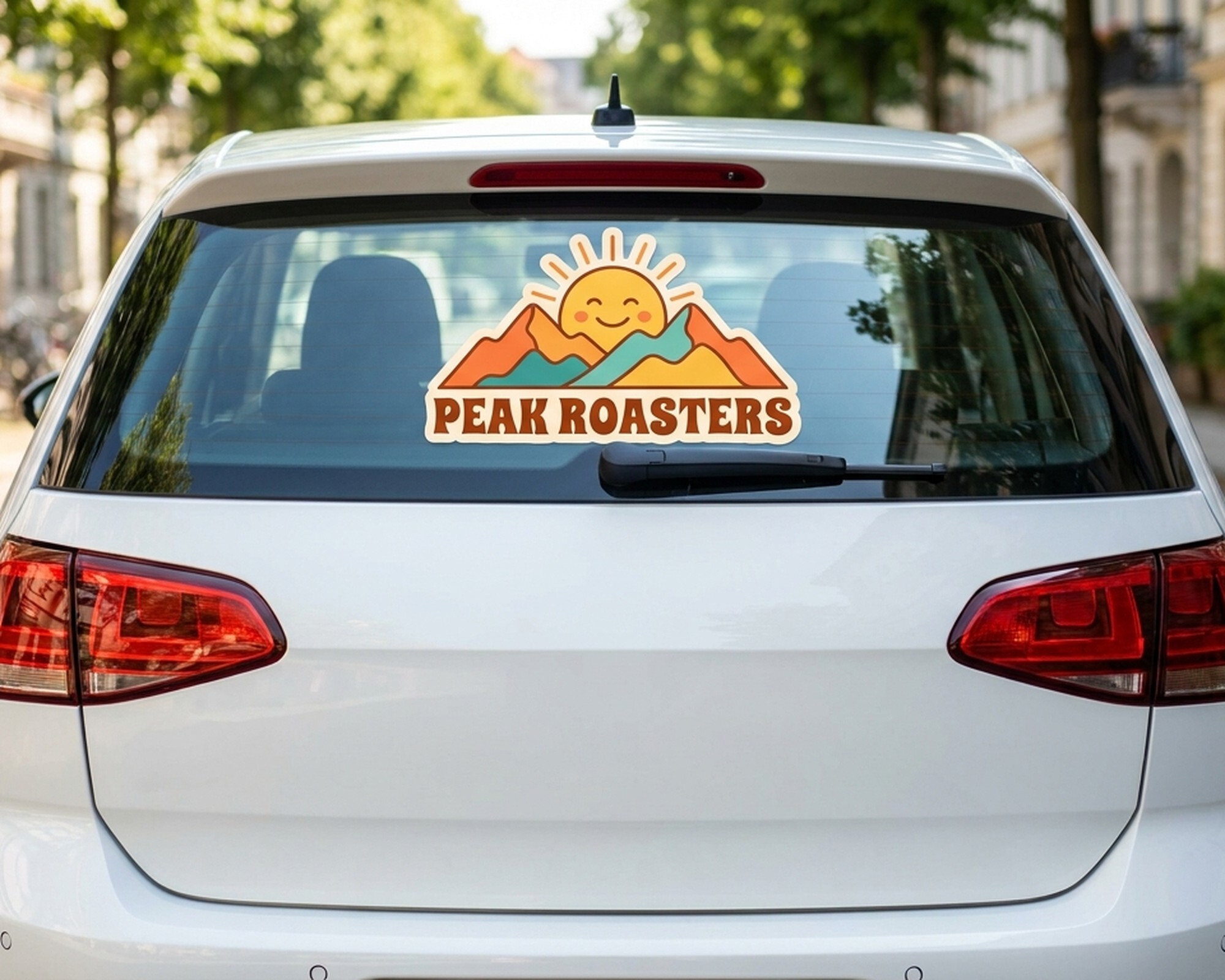 Contourgesneden eigen decal met een logo van zon en bergen en de tekst "Peak Roasters" op de achterruit van een auto
