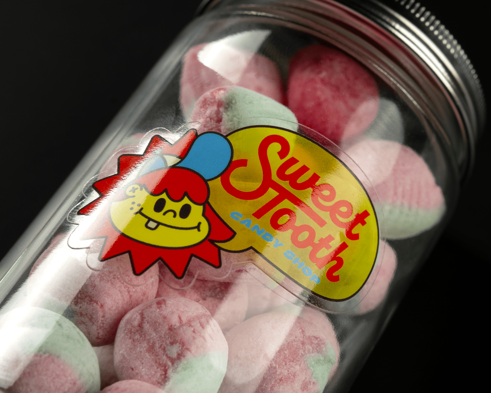 Jar of pink and green marshmallows with a "Sweet Tooth Candy Shop" label featuring a cartoon character.