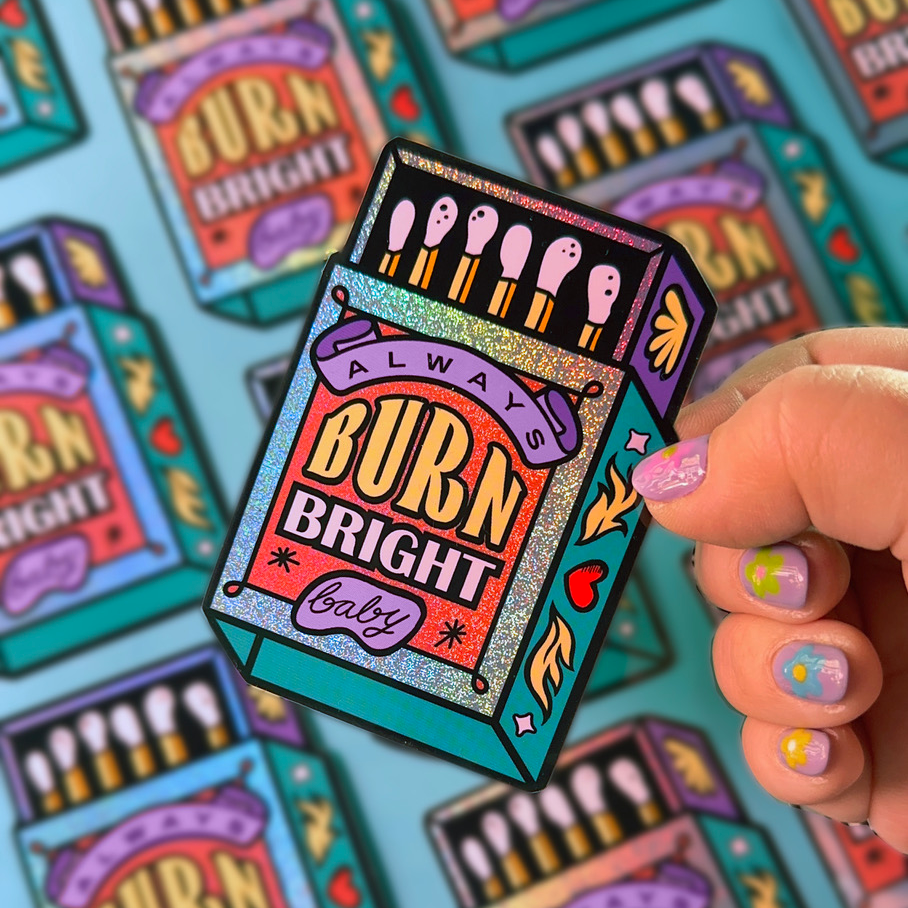 Die cut stickers on Pixie Dust showing a match box with the quote "burn bright".